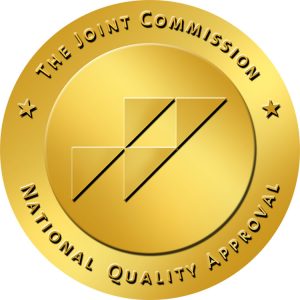 A gold circular certification badge with the text 